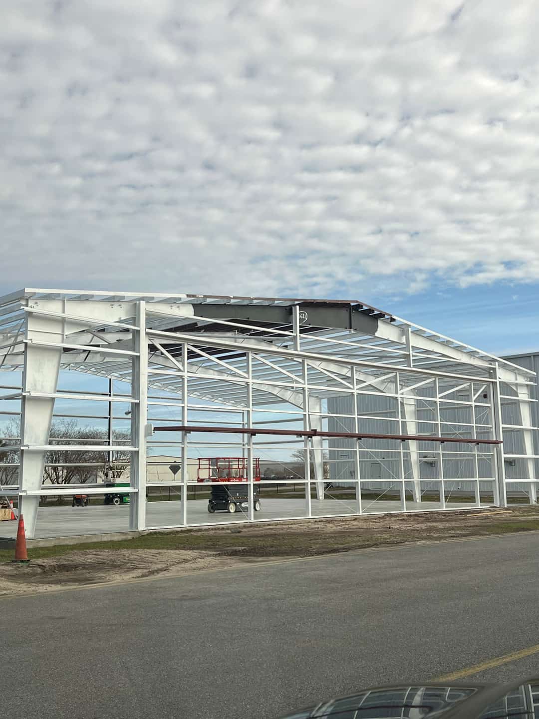 Commercial painting contractor recoating exposed metal building frame in Baldwin County, AL